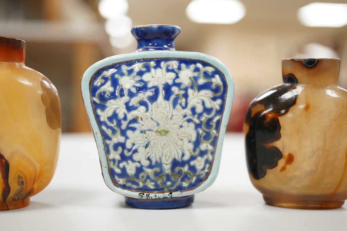 Three 19th century Chinese agate snuff bottles and a porcelain snuff bottle, largest 6cm high (4)